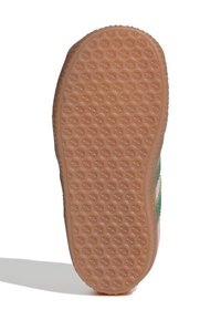 Shoe outsole with a textured pattern of small stars, light brown color, rounded shape, and a slight curve at the edges.