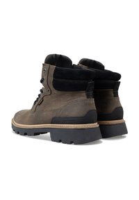 Bruine leren en suede enkellaarzen met zwarte accenten, voorzien van een robuuste rubberen zool en een vetersluiting voor een veilige pasvorm.