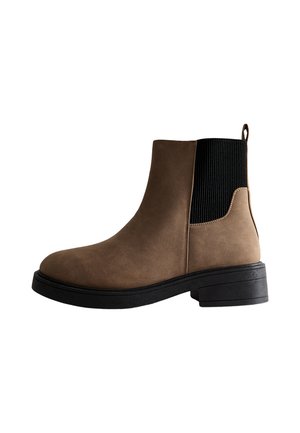 Botines marrones con un acabado de ante sintético suave, paneles laterales elásticos y un resistente tacón cuadrado negro. Presentan una tira en la parte posterior.