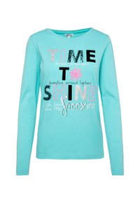 Pitkähihaisessa turkoosipaidassa on erilaisia värikkäitä tekstejä ja kuvioita, mukaan lukien lumihiutalekuvio ja slogan-tietoja. Pehmeä kankaan rakenne.