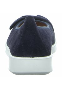 Granatowe zamszowe buty widziane z tyłu, z okrągłym noskiem i białą gumową podeszwą. Posiadają dekoracyjny akcent w postaci kokardy na cholewce.