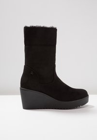 Botte compensée noire mi-mollet avec doublure en fausse fourrure et semelle crantée, conçue pour l'hiver et un style sophistiqué.