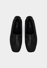 Ζευγάρι μαύρα δερμάτινα παπούτσια slip-on με τετράγωνες μύτες, ελάχιστη ραφή και μαύρες εσωτερικές σόλες με την επωνυμία "Calvin Klein".