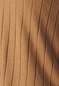 Brązowa tkanina ze żłobieniami, z pionowymi liniami i miękką teksturą, idealna do odzieży lub tapicerki, w ciepłym, ziemistym odcieniu.