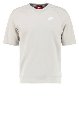 Sweatshirt léger beige clair à manches courtes Nike avec col rond et logo Nike blanc sur la poitrine gauche.