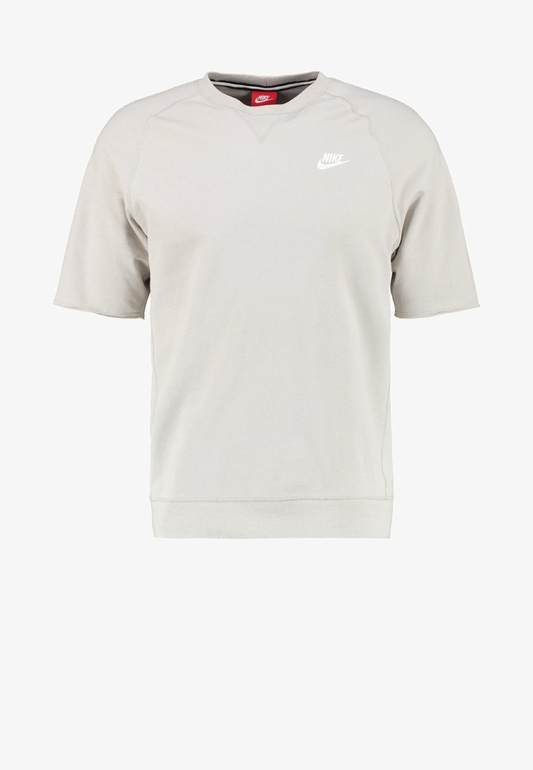 Světle béžová mikina Nike s krátkým rukávem a kulatým výstřihem, s bílým logem Nike na levé hrudi.