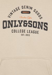 Beżowa bluza z kapturem z ciemnym nadrukiem. Z przodu widnieje napis "Vintage Denim Goods" oraz "Only & Sons College League" z pomarańczowym akcentem. Posiada kieszeń kangurzą.