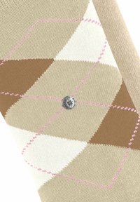 Il tessuto a maglia presenta un motivo geometrico a argyle beige, marrone e bianco, con cuciture rosa. È visibile un bottone logo in argento.