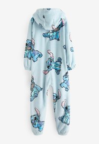 Fleece-yksiosainen asu vaaleansinisessä värissä, jossa on toistuva Stitch-hahmon kuvasto. Asussa on huppu ja joustavat hihansuut ranteissa ja nilkoissa.