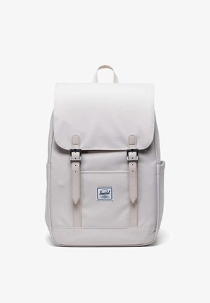 Svijetlosmeđi ruksak izrađen od izdržljive tkanine, s preklopom, dva prednja remena s kopčama i prednjim džepom s logom.