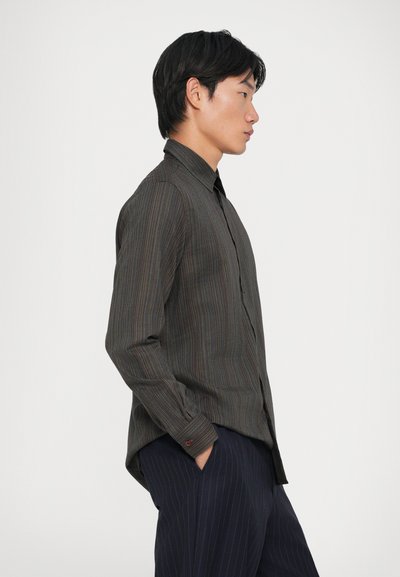 Camisa de manga larga a rayas hecha de tejido entrelazado, con una base oscura y rayas verticales multicolores, y un cuello abotonado.