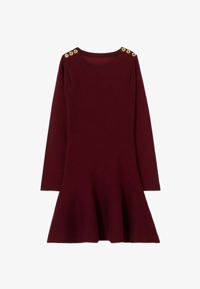 Abito borgogna con maniche lunghe, gonna svasata e dettagli in oro sui lati delle spalle. Realizzato in morbido tessuto a maglia, presenta un colletto rotondo.