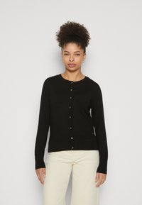Zwarte langärmige cardigan gemaakt van een glad gebreide stof met gouden knoopsluiting en een ribbelachtige afwerking bij de kraag en de zoom.