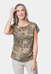 Korte mouw top in een patroon met aardse tinten van geel, bruin en zwart, met een ronde halslijn en een losse pasvorm.