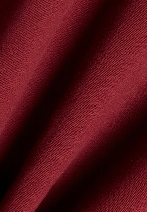 Gewebter Stoff in einem tiefroten Farbton, glatte Textur, mit sichtbaren diagonalen Rippenmustern und weichem Fall.