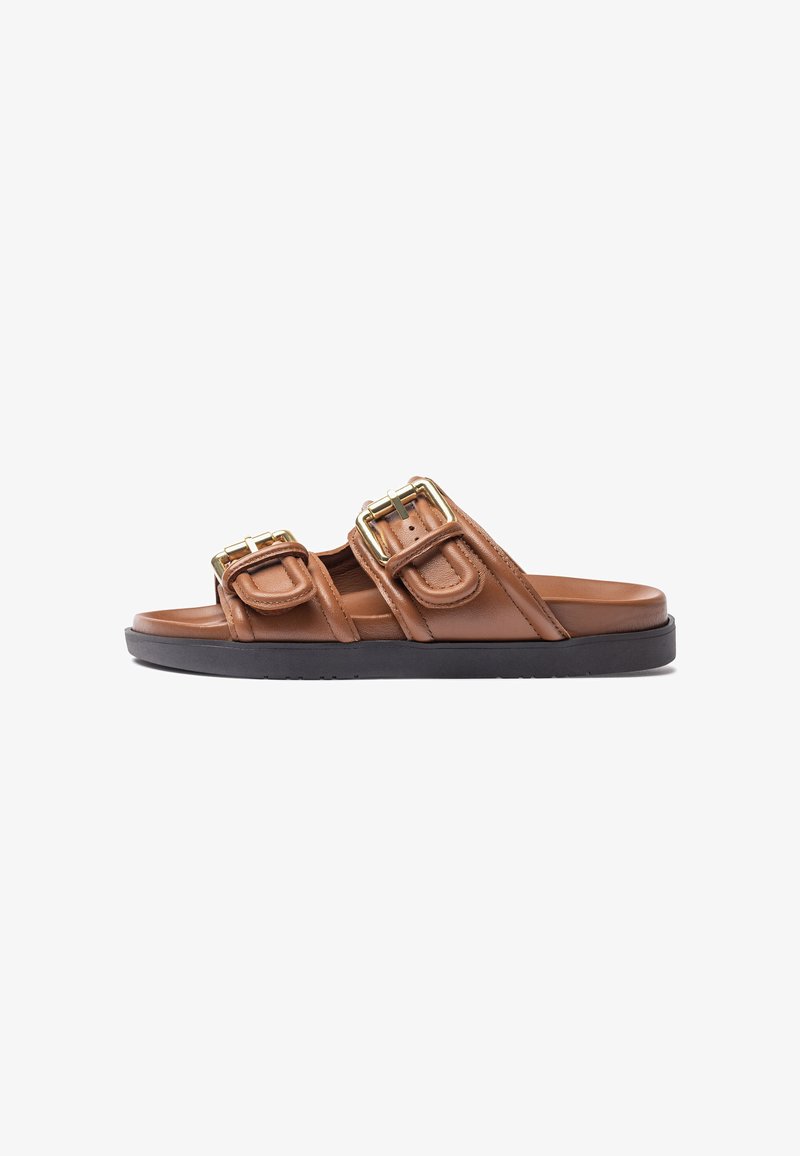 Sandales glissantes en cuir marron avec deux boucles dorées proéminentes, une texture lisse et une semelle en caoutchouc noir. Conçues pour un port décontracté.