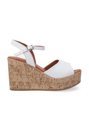 White wedge sandals featuring a smooth upper, ankle strap with a buckle, and a textured light brown cork platform.