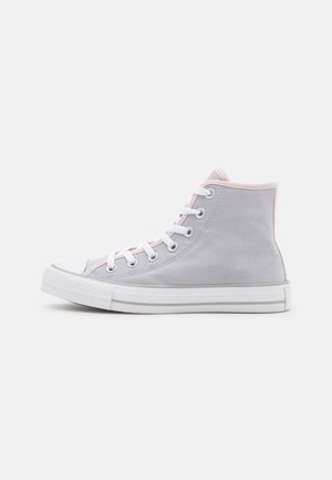 Zapatilla deportiva de caña alta de color gris claro con cordones blancos, suela de goma y un sutil borde rosa alrededor del tobillo y la lengüeta.