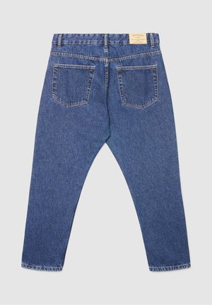 Pantalon en denim bleu à coupe décontractée, avec une taille munie de passants pour ceinture, deux poches plaquées à l'arrière, et une texture à effet délavé clair.