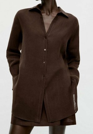 Braunes Leinen-Langarmhemd mit durchgehendem Knopfverschluss, spitzem Kragen, legerer Passform und Seitentaschen. Strukturierter Stoff, leicht transparenter Saum.