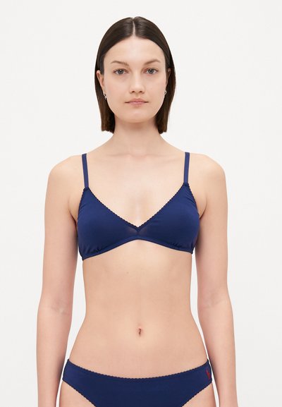 Ναυτικό μπλε τριγωνικό bralette με λεπτές ρυθμιζόμενες τιράντες, κυματιστές λεπτομέρειες στις άκρες και μαλακό ύφασμα. Διαθέτει απλό σχέδιο.