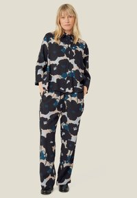 Blomstermønstret sæt med en løstsiddende skjorte og brede bukser i sort, teal og beige. Blødt stof med knapdetaljer.