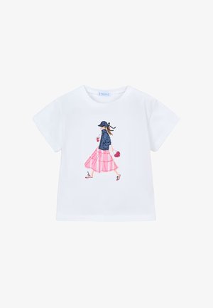 Maglietta bianca a maniche corte con un'illustrazione di una donna che cammina, indossando una giacca blu navy, una gonna rosa, un berretto e portando una borsa a forma di cuore.