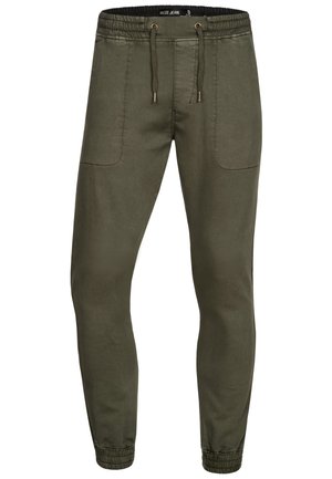 Olive green jogger pants with elastic waistband, drawstring, front patch pockets, and elastic cuffs at ankles.