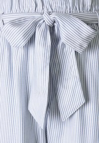 Blau und weiß gestreifter Stoff mit strukturierter Oberfläche, versehen mit einer gebundenen Schleife in der Taille und einem elastischen Taillenbund.