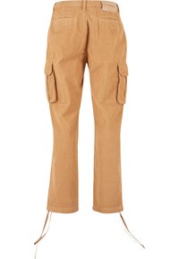 Pantalon cargo en velours côtelé beige avec poches à rabat sur les côtés, poches à passepoil à l'arrière et liens ajustables aux ourlets, vu de dos.