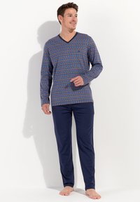 Long-sleeve, V-neck pajama top in a blue and red geometric pattern paired with solid navy pants. Made of soft, lightweight fabric.