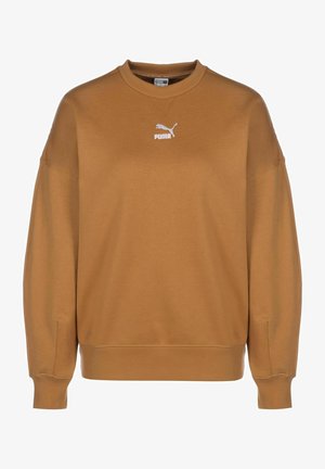 Sudadera marrón hecha de un tejido suave, con un cuello redondo, hombros caídos y un logo blanco de Puma en el pecho. Textura lisa.