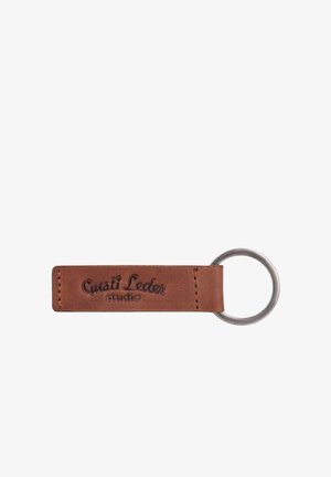 Brown leather keychain tag with stitched edges and a metal ring, embossed with the text "Gusti Leder studio."