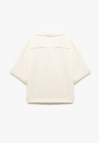 Kortærmet, kridhvid skjorte lavet af et struktureret materiale, med en bagfold og et klassisk kravedesign.