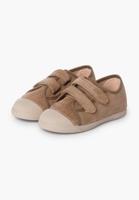 Des chaussures en velours côtelé marron avec des orteils arrondis, dotées de deux sangles Velcro et de semelles en caoutchouc texturé. Un design simple avec des matériaux contrastants.