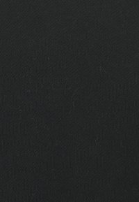Tessuto di maglia nera, texture elastica, colore uniforme con leggere variazioni nelle fibre, senza pattern o disegni visibili. Adatto a diversi usi.