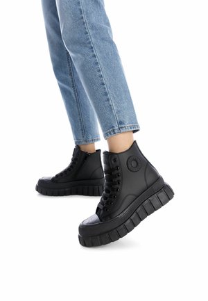 Zapatillas de deporte altas negras fabricadas en cuero suave con una suela de goma texturizada, que presentan ojales para los cordones y un detalle de cremallera lateral.