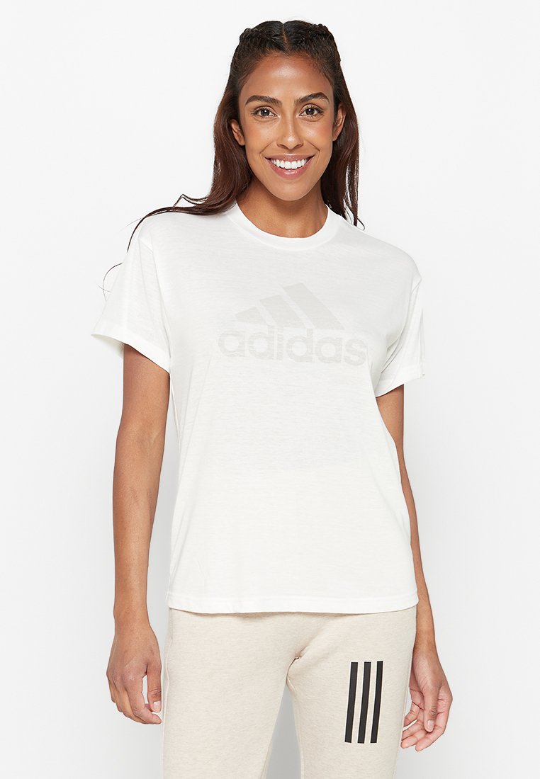 T-shirt bianco in cotone con maniche corte, caratterizzato da un logo Adidas grigio chiaro sul petto. Tessuto morbido e vestibilità rilassata.