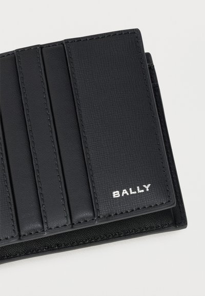 Μαύρο δερμάτινο πορτοφόλι μερικώς ανοιχτό που δείχνει πολλαπλές θήκες για κάρτες και το λευκό λογότυπο Bally σε υφασμένο δερμάτινο πάνελ.