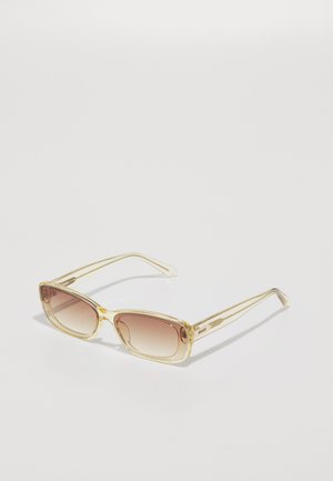 Lunettes de soleil teintées ambre avec une monture rectangulaire, fabriquées en plastique transparent jaune. Elles présentent des branches fines et angulaires avec un branding subtil.