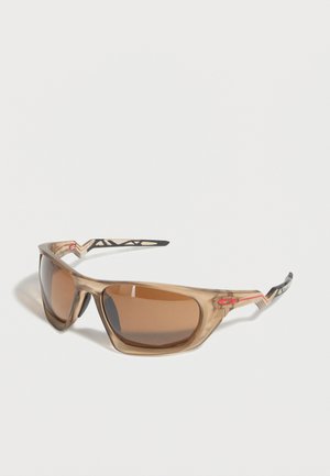 Wraparound-Sportsonnenbrille mit braun getönten Gläsern und durchsichtig beigem Rahmen, der schwarze und rote Akzente an den Bügeln aufweist.