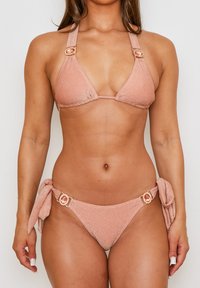 Roze glinsterende bikini met een driehoektop en strikzijdelen, versierd met decoratieve hardware accenten bij de bandjes en zijkanten.