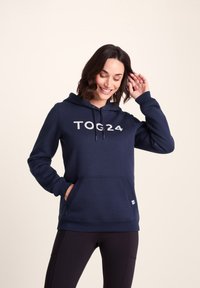 Navy blue hoodie with a kangaroo pocket, drawstring hood, and "TOG24" printed in white on the front. Made from soft, textured fabric.
