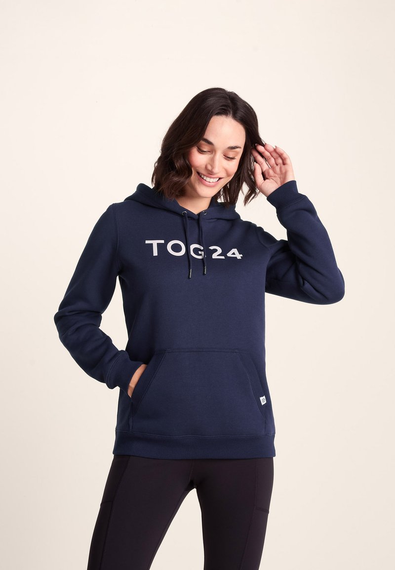 Navy blue hoodie with a kangaroo pocket, drawstring hood, and "TOG24" printed in white on the front. Made from soft, textured fabric.