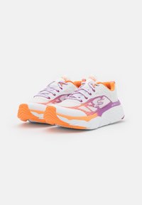 Zapatillas deportivas blancas con acentos en morado y naranja, parte superior de malla, suela gruesa y detalles texturizados en la suela exterior. Diseñadas para comodidad y soporte.