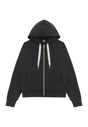 Sweat à capuche noir avec fermeture éclair, cordons beige, deux poches avant, poignets et ourlet côtelés, et un petit logo circulaire près de l'ourlet inférieur.