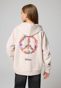 Sudadera de color beige claro con un diseño de símbolo de paz floral en la parte posterior y el texto "AllSaints". Cuenta con capucha y puños de canalé.