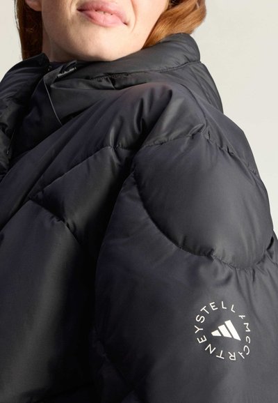 Puchowa czarna kurtka z wysokim kołnierzem, z pikowanym wzorem oraz białym logo na lewym rękawie. Gładka, błyszcząca powierzchnia.