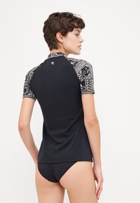 Black short-sleeve rash guard with patterned shoulders, made of stretchy material, featuring a high neckline and a fitted design.
