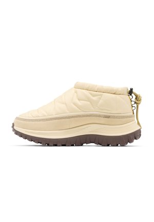 Chaussure beige rembourrée sans lacets avec une semelle intermédiaire beige épaisse et une semelle extérieure marron foncé robuste, comportant un onglet avec cordon réglable au talon.